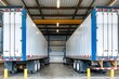 Professional grade Big rig blue semi truck with open door empty semi trailer standing at warehouse parking lot at industrial area waiting for the commercial load for the next delivery