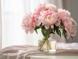 Peonies in a glass vase create an elegant focal point on a table