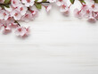 Flat lay composition showcases a cherry tree branch with blossoms on a white table
