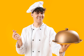 Canvas Print - Male chef making heart with his fingers on yellow background