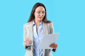 Wall Mural - Young businesswoman with bottle of water and papers on color background