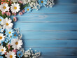 Overhead view displays a frame of spring flowers against a blue wooden backdrop