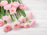 Fresh pink eustoma flowers grace a white wooden background
