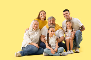 Big family sitting on yellow background