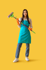 Wall Mural - Young woman with floor mop on yellow background