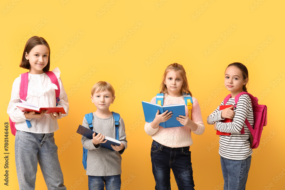 Little schoolchildren reading  books on yellow background