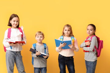 Canvas Print - Little schoolchildren reading  books on yellow background