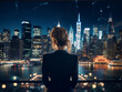 Elegant businesswoman's rear view as she admires the city lights at night