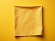 A yellow kitchen napkin rests neatly on a table, offering space for creativity