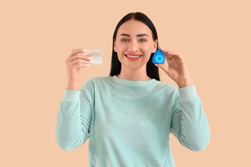 Sticker - Beautiful young happy woman with dental floss and mini toothbrushes on beige background