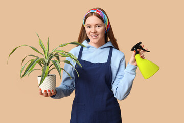 Sticker - Pretty young woman with houseplant and water sprayer on beige background