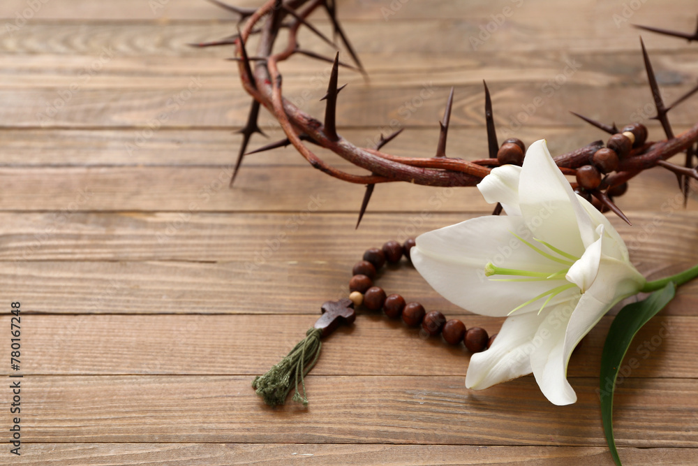 White lily and prayer beads on wooden background