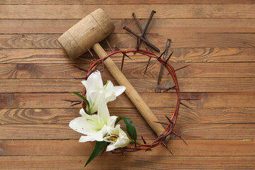 Wall Mural - Crown of thorns with white lilies, hammer and nails on wooden background