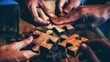 people are connecting wooden puzzle pieces together, symbolizing collaboration and unity in teamwork