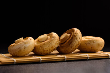 Wall Mural - Fresh organic button mushroom placed on black background. Local ingredient for healthy vegetarian meal