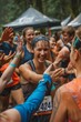 © ktianngoen0128 - A diverse group of runners high-fiving at a water station