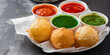 plate of pani puri with white paper cups filled with green and red sauce, generative AI