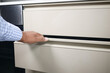 man's hand open drawer wooden in cabinet
