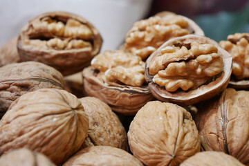 Wall Mural - A scoop of walnuts, a superfood, rests on a stack of nuts seeds