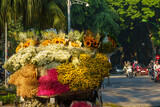 Fototapeta Miasto - Rear view of street flower vendor seller on bicycle in Old Quarter in Hanoi, Vietnam..