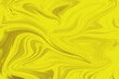 Abstract yellow liquid paint effect blurred rough background texture overflow waves. Poster background.