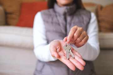 Wall Mural - Closeup image of a woman holding and giving the keys for real estate concept