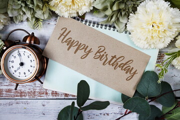 Poster - Happy Birthday text message on paper card with flowers border frame on wooden background