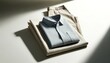 A neatly folded linen shirt and trousers set against a clean, light background, representing classic, effortless style.