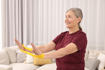 Sticker - Senior woman doing exercise with fitness elastic band at home