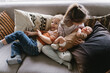 © Cavan Images - a growing family of siblings snuggling on the couch with newborn