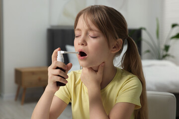 Canvas Print - Little girl using throat spray at home