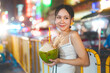 Asian tourist woman eating coconut juicetraveling at China town asia street food night market