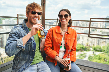Wall Mural - A man and a woman enjoy each others company on a bench, sipping beer together