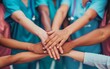 © Evodigger - Hands of medical professionals in scrubs and stethoscopes come together to form a unity sign.