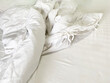 Soft and calm atmosphere image of all white bed room. Pillows and blanket on empty bed, close up