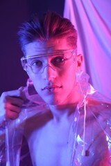 Poster - Stylish young man wearing clear coat and glasses in neon lights