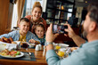 © Drazen - Happy family having fun while taking picture during their breakfast in  restaurant.