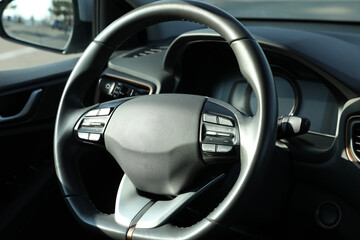 Wall Mural - Black steering wheel inside of modern car, closeup