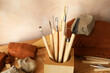 Clay and set of modeling tools on wooden table in workshop, closeup