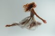 A woman in a flowing dress is captured in a moment of weightless grace, likely a dancer in motion.