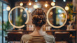 Rear view of a young woman with a beautiful hairstyle who is sitting in a beauty salon