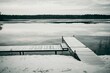 Vintage shot of a lake landscape with calm waters and a wooden dock in a rural area