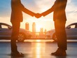Silhouette of two people shaking hands in front of cars with a sunset backdrop, concept for successful car buying