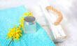 a jar of cream and a blooming branch with yellow flowers on an emerald towel. spa and freshness atmosphere