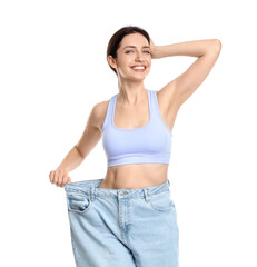 Wall Mural - Happy young woman in big jeans showing her slim body on white background