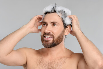 Poster - Happy man washing his hair with shampoo on grey background, closeup