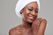 © peopleimages.com - Woman, portrait and towel in studio for hygiene cleaning or healthy transformation, shower or grey background. Black person, face and smile for morning routine with dermatology, skincare or mockup