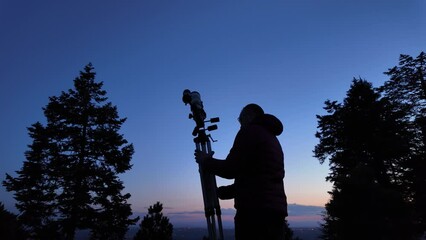 Wall Mural - amateur astronomer looking at the evening skies, observing planets, stars, moon and other celestial 