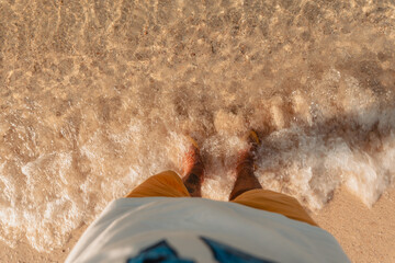 Wall Mural - Feet at the beach by the sea in the evening