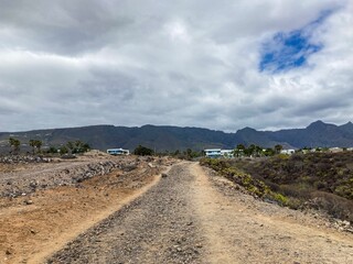 deserted land with trees and the mountains in the background under the cloudy sky in corfu, greece